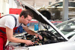 Automechaniker in einer Werkstatt repariert Fahrzeug